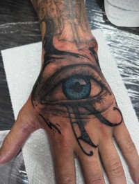 realistic tattoo of an eye on the back of a hand