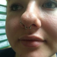 A girl with nostril and septum piercings