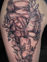 tattoo of an arrowhead with desert scenes inside them and cacti around them
