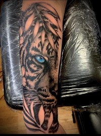 A tattoo of a tiger with a blue eye