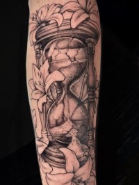 illustrative tattoo of a black and grey hourglass with flowers