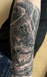 a realistic black and white tattoo of a lion's head