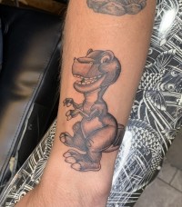 A black and white tattoo of Chomper from the "Land Before Time" cartoon