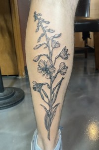 illustrative tattoo of a flower on the back of the calf