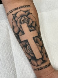 black and grey tattoo of a cross with roses