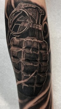 Black and white tattoo of a hand grenade