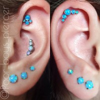 Two ears pierced with several blue bejeweled studs