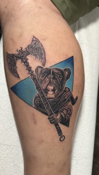 a tattoo of a French bulldog holding a double axe