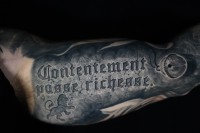 black and grey realism tattoo on script in stone